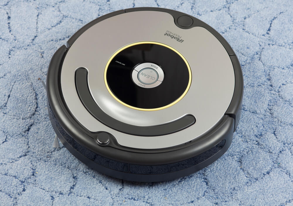 iRobot Roomba vacuum cleaner at the top of the carpet