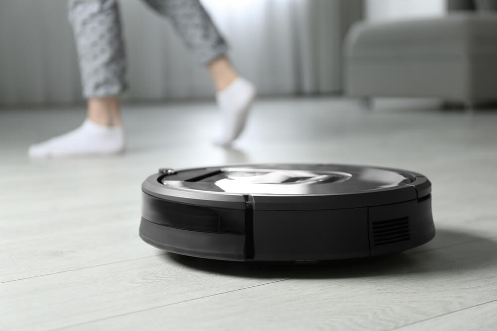 Are Robot Vacuums Good to Use On Tile Floors - a robot vacuum cleaner cleaning, a person