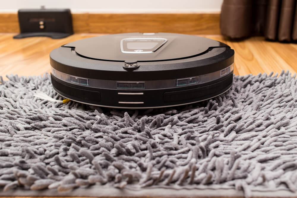 How Long Do Roomba Batteries Last - A robot vacuum cleaner in the top of the carpet